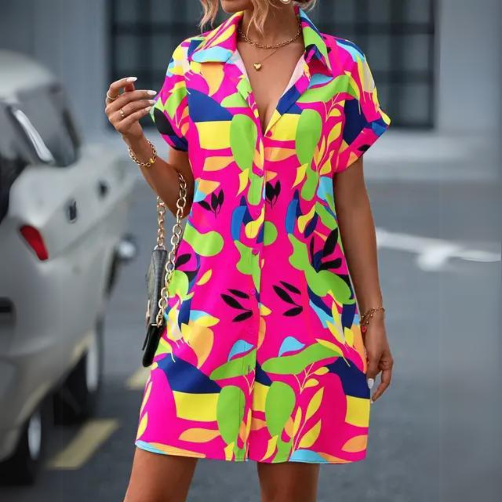 Abito estivo donna colorato con motivi astratti, maniche corte, sfondo urbano. Moda casual, stile vivace, perfetto per la stagione calda.