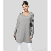 Donna con felpa oversize grigia con cappuccio, maniche lunghe, su sfondo grigio. Moda casual, abbigliamento comodo, stile autunnale.