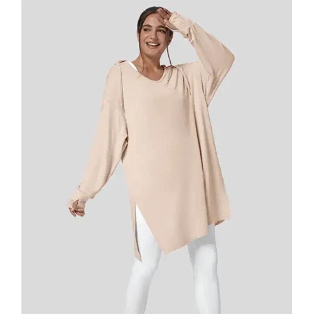 Modella indossa tunica beige oversize con maniche lunghe e leggings bianchi. Moda donna casual, abbigliamento comodo, stile autunnale.