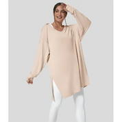 Modella indossa tunica beige oversize con maniche lunghe e leggings bianchi. Moda donna casual, abbigliamento comodo, stile autunnale.