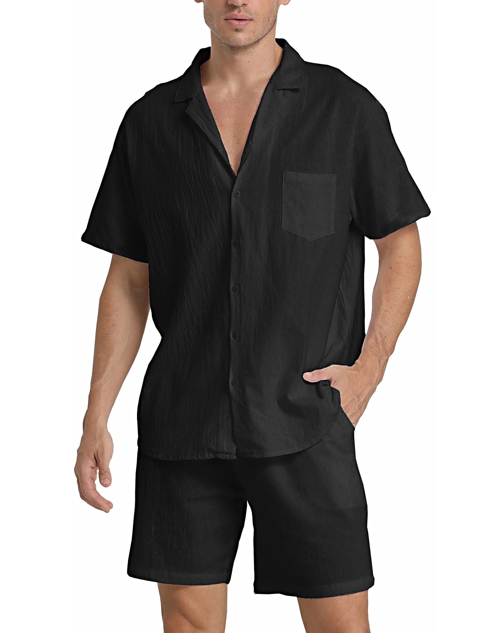 Camicia nera da uomo a maniche corte con colletto classico e taschino, abbinata a pantaloncini neri. Look estivo casual ed elegante.