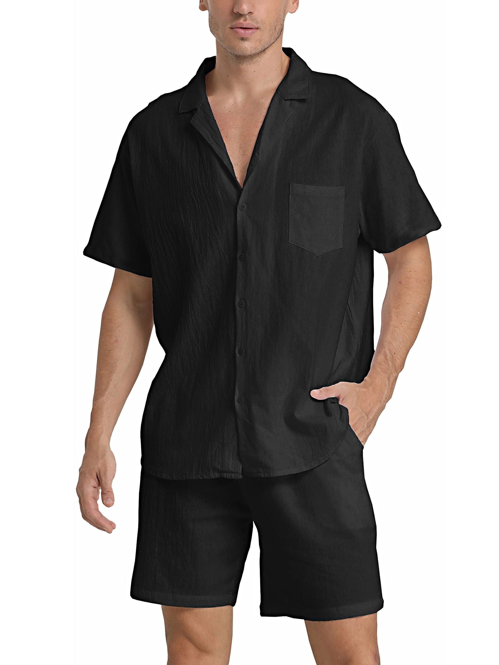 Camicia nera da uomo a maniche corte con colletto classico e taschino, abbinata a pantaloncini neri. Look estivo casual ed elegante.