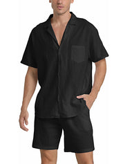 Camicia nera da uomo a maniche corte con colletto classico e taschino, abbinata a pantaloncini neri. Look estivo casual ed elegante.