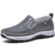Scarpa slip-on da uomo grigia, traspirante, suola antiscivolo, ideale per attività outdoor. Design sportivo e confortevole.