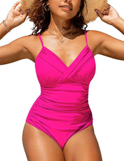 Donna in costume intero rosa acceso, spalline sottili, design incrociato, indossa cappello di paglia. Moda mare, abbigliamento estivo donna.