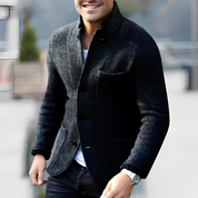 Giacca uomo elegante in lana nera, stile casual, con tasche frontali e bottoni, indossata su maglietta bianca. Moda maschile autunno-inverno.