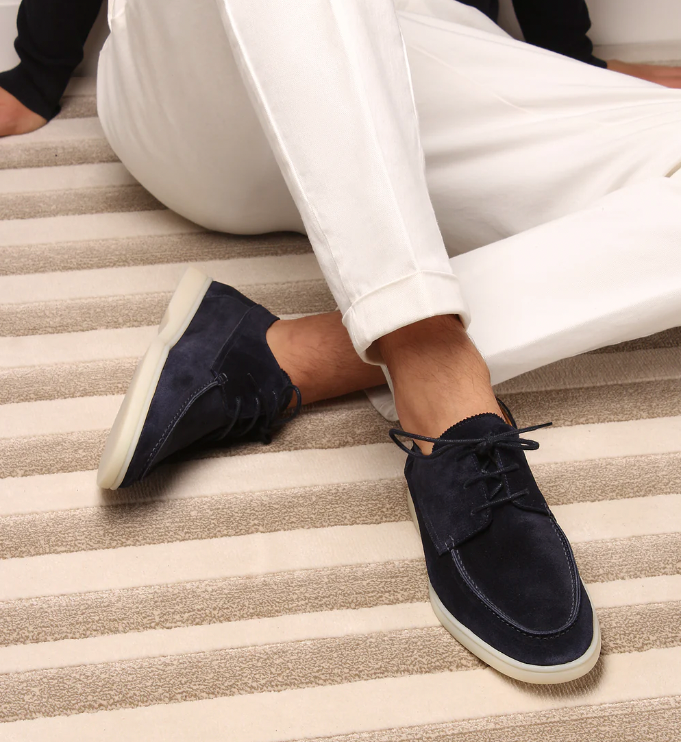 Scarpe da uomo in camoscio blu, eleganti e casual, abbinate a pantaloni bianchi. Ideali per look estivi e primaverili. Suola chiara antiscivolo.