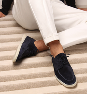 Scarpe da uomo in camoscio blu, eleganti e casual, abbinate a pantaloni bianchi. Ideali per look estivi e primaverili. Suola chiara antiscivolo.