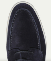 Scarpa da uomo in pelle scamosciata blu navy, vista dall'alto, con cuciture decorative e suola bianca. Elegante e casual, perfetta per ogni occasione.