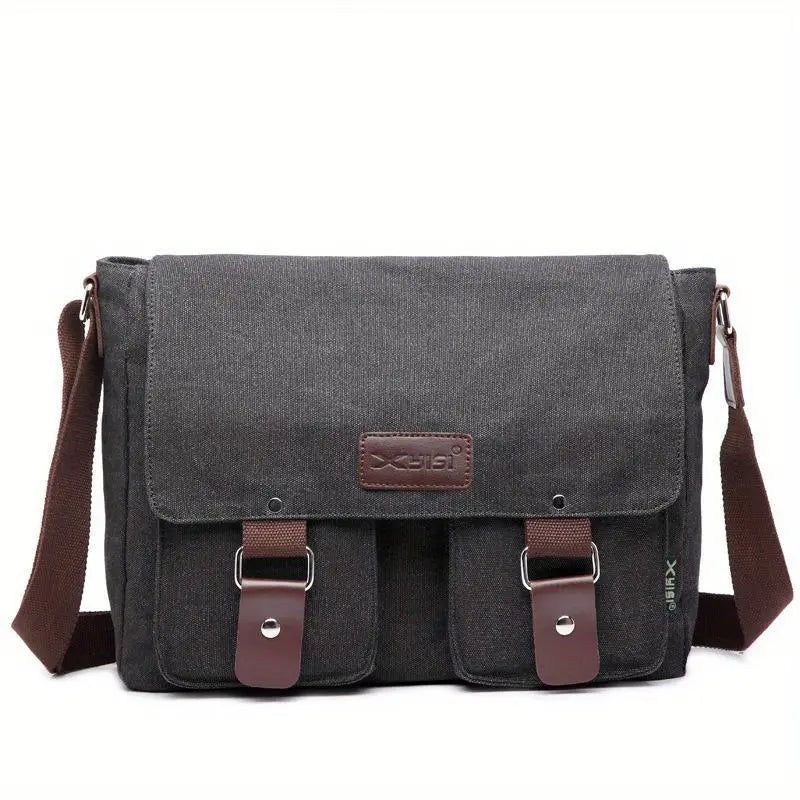 Borsa a tracolla in tela grigia con patta, tasche frontali e dettagli in pelle marrone. Design unisex, ideale per lavoro e tempo libero.