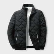 Giacca trapuntata nera da uomo con zip, colletto alto e tasche laterali. Design moderno, ideale per l'inverno. Moda maschile, abbigliamento casual.