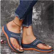 Sandali infradito donna in denim blu con decorazioni, suola in gomma marrone, abbinati a jeans strappati. Calzature estive eleganti e casual.