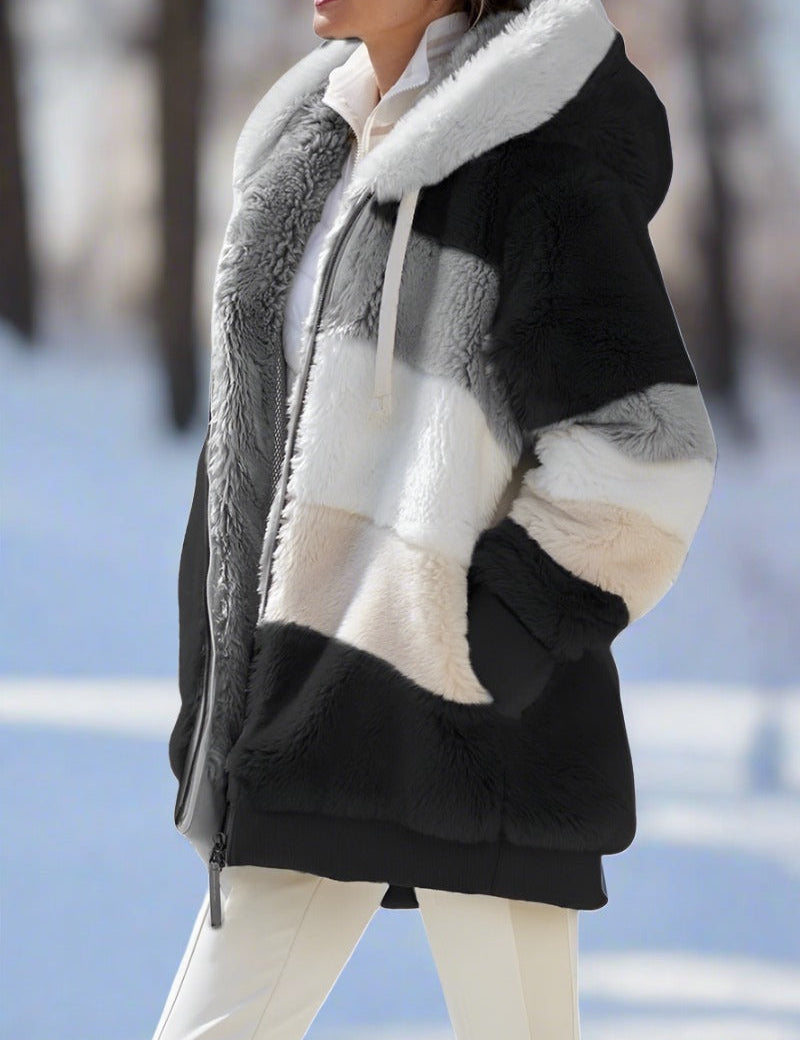 Giacca invernale donna in pelliccia sintetica a blocchi di colore, cappuccio, chiusura zip, sfondo innevato. Elegante e calda per l'inverno.