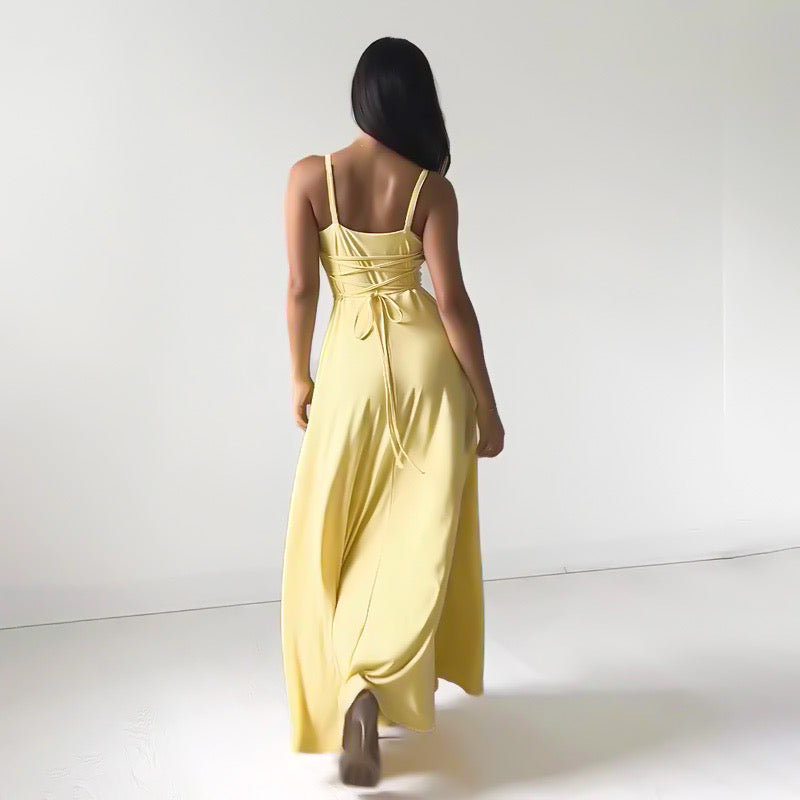 Abito lungo giallo elegante, donna di spalle, design con spalline sottili e schiena scoperta, moda estiva, abbigliamento femminile chic.