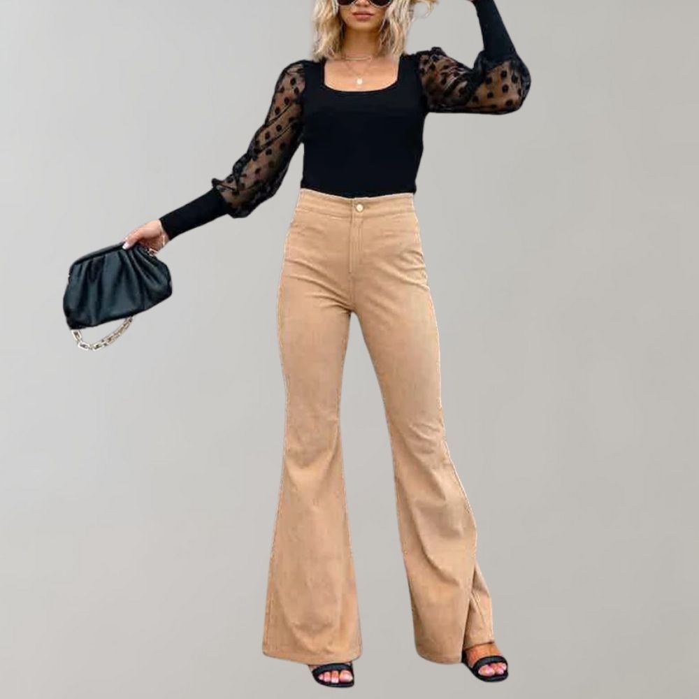 Donna con top nero a maniche lunghe trasparenti e pantaloni a zampa beige, borsa nera, sandali neri. Moda elegante, abbigliamento casual chic.