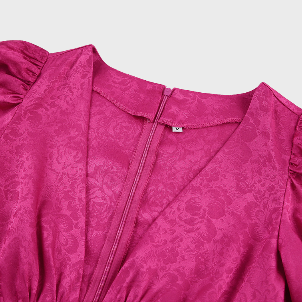 Vestito rosa fucsia in raso con motivo floreale, scollo a V e maniche a sbuffo. Chiusura con zip posteriore. Taglia M. Elegante e alla moda.