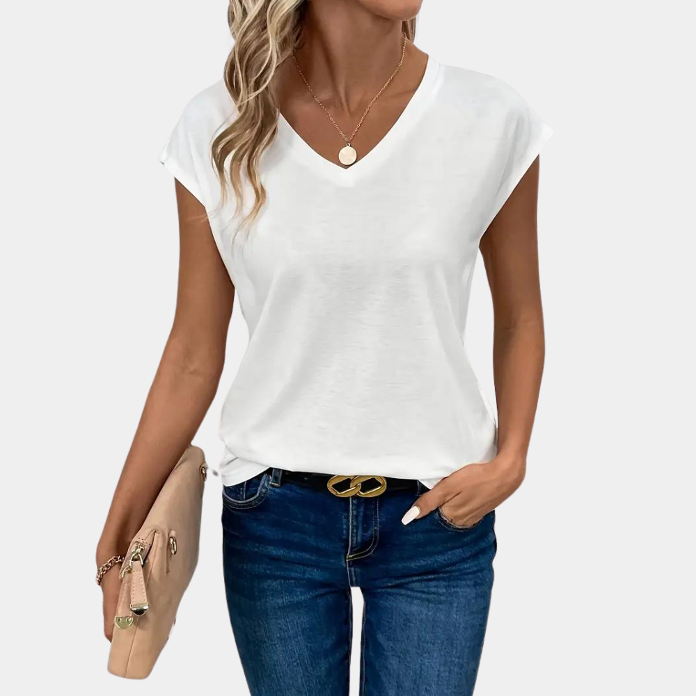 Donna con maglietta bianca a V, jeans blu e borsa beige. Moda casual estiva, abbigliamento femminile trendy, accessori eleganti.