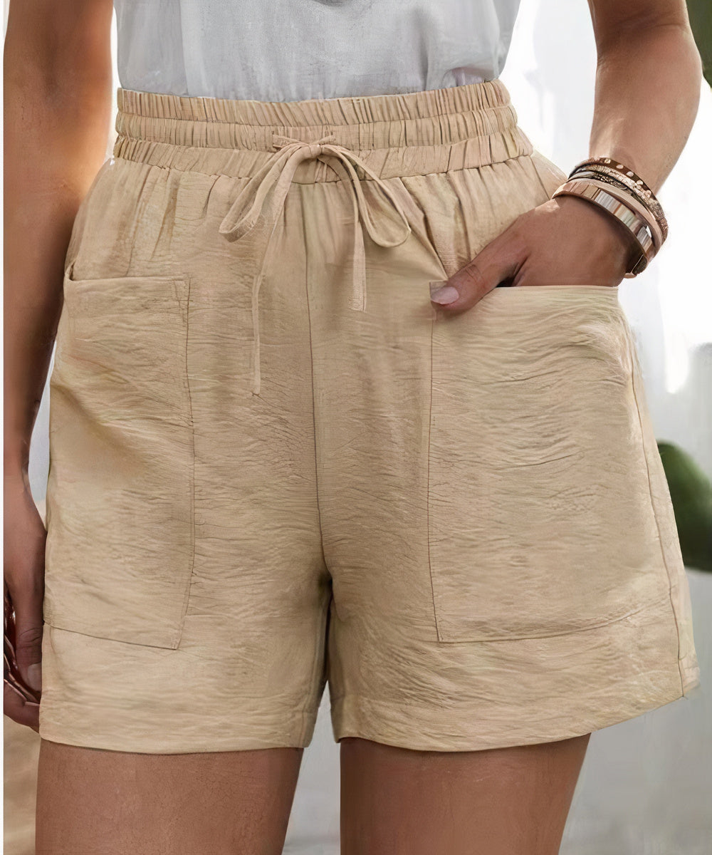 Shorts beige da donna con tasche frontali, elastico in vita e laccio. Design casual estivo, tessuto leggero. Ideale per moda femminile estiva.