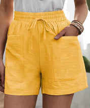 Shorts gialli da donna con tasche frontali, elastico in vita e laccio. Stile casual estivo, tessuto leggero. Ideali per moda femminile estiva.