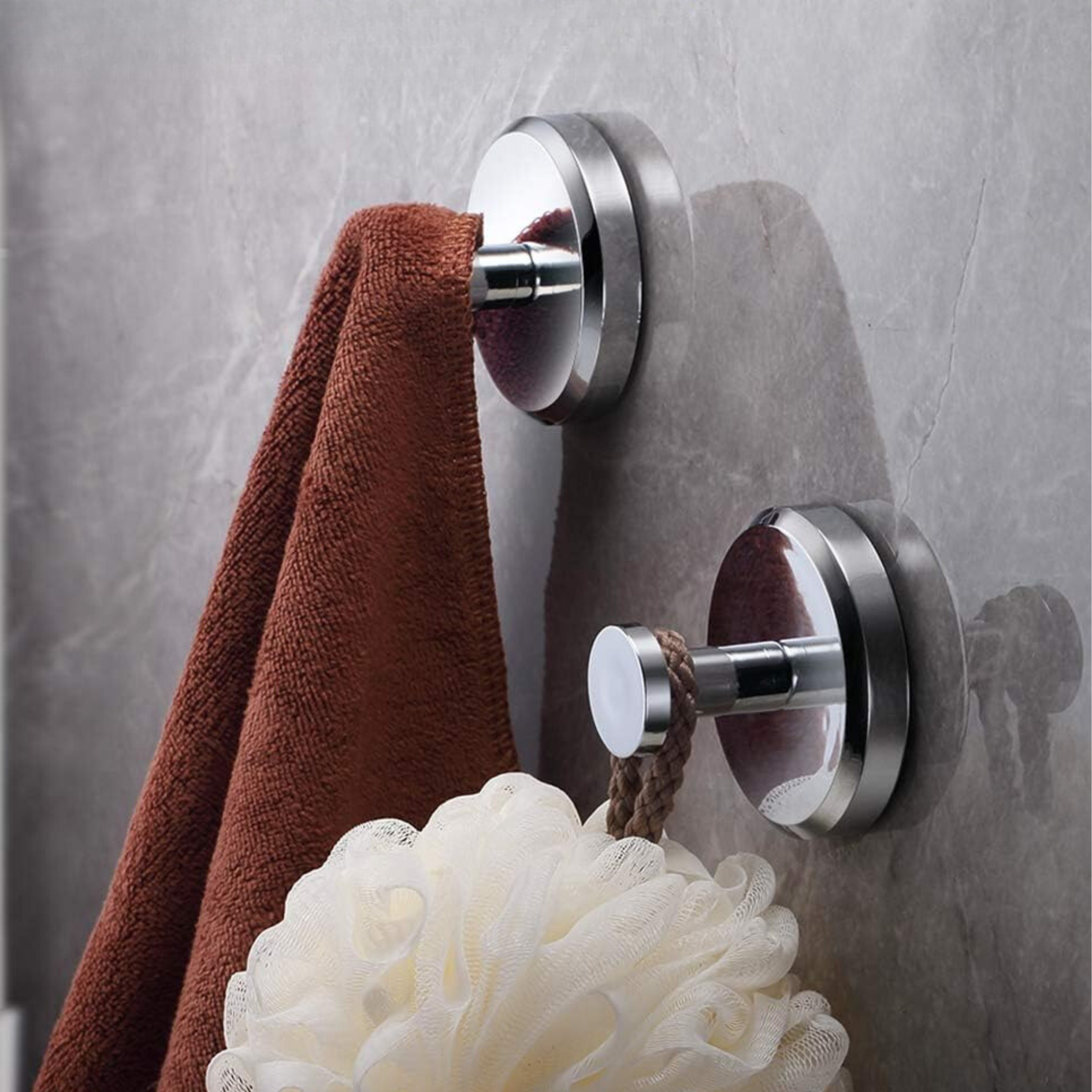 Ganci da parete in acciaio inox con asciugamano marrone e spugna da bagno, montaggio senza fori, accessori bagno moderni, design elegante.