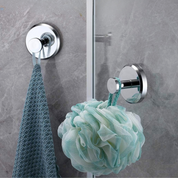 Ganci adesivi in acciaio inox su parete bagno, reggono spugna doccia verde e asciugamano blu. Accessori bagno moderni, resistenti all'acqua.