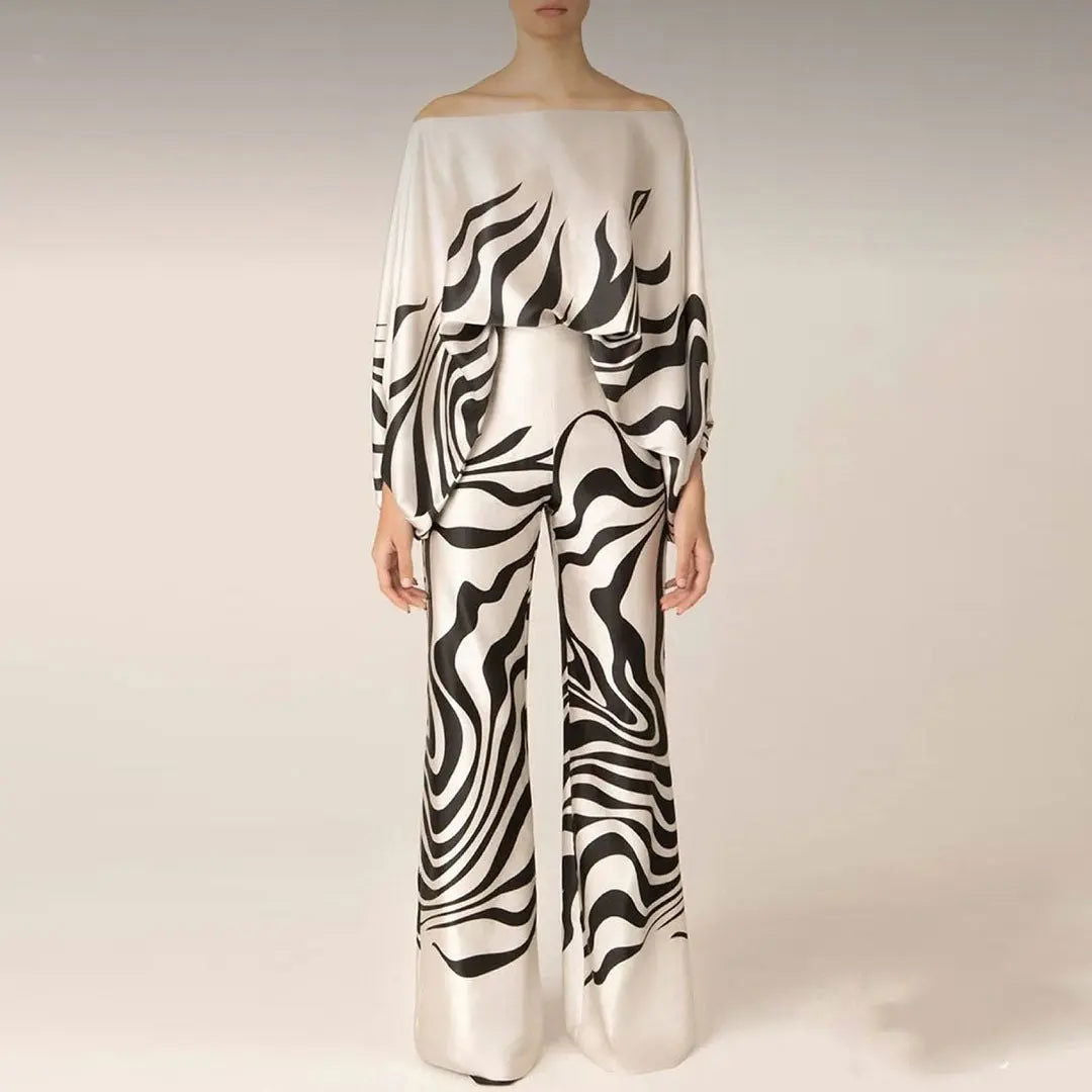 Abito elegante bianco e nero con motivo astratto, maniche lunghe e pantaloni larghi. Moda donna, stile sofisticato, tendenza 2023.