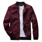 Giacca bomber uomo bordeaux con zip, colletto e polsini neri, tasca sulla manica, abbinata a t-shirt bianca. Moda casual, stile urbano.