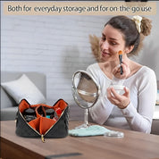 Donna che si trucca con specchio, accanto a borsa cosmetica nera con zip aperta, contenente trucchi. Ideale per organizzazione e uso quotidiano.