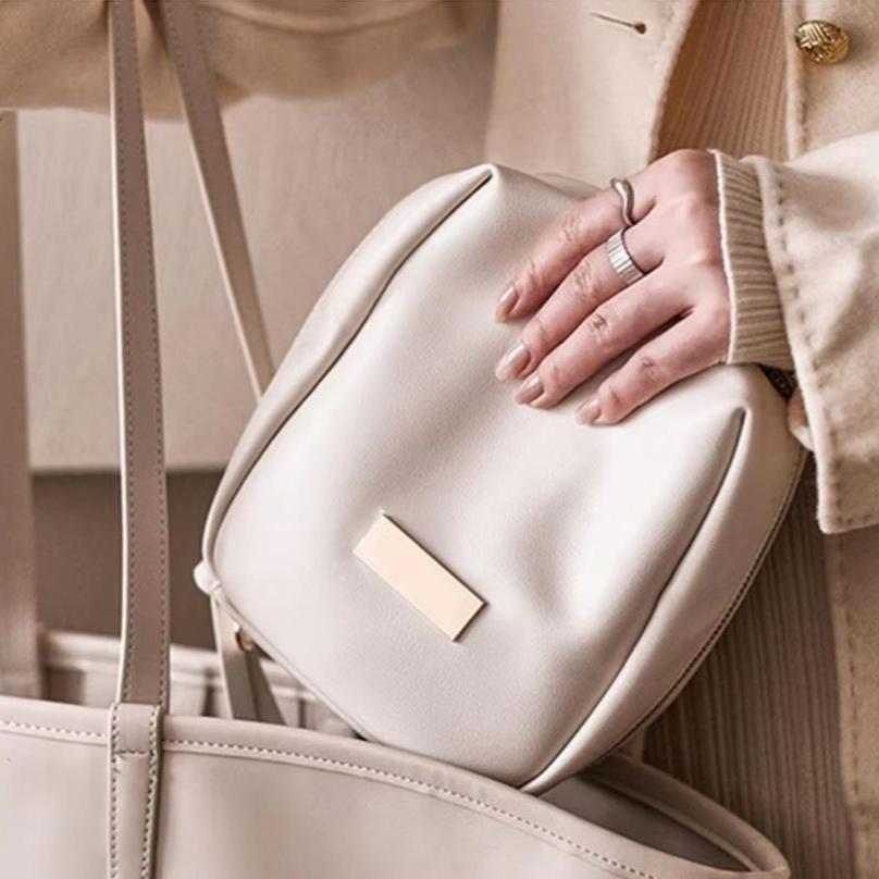 Borsa a tracolla beige in pelle, design elegante, chiusura con zip, ideale per moda femminile, accessorio di tendenza, stile casual chic.