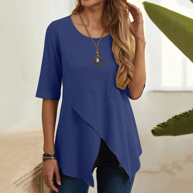 Donna con maglia blu asimmetrica, maniche corte, collana dorata. Moda casual elegante, abbigliamento estivo femminile.