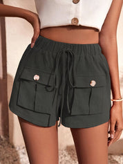 Shorts neri da donna con tasche frontali e bottoni, indossati con top bianco. Stile casual estivo, perfetto per moda femminile e abbigliamento trendy.