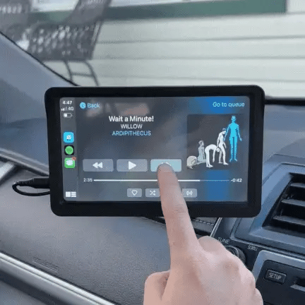 Schermo touchscreen auto con interfaccia musicale, brano in riproduzione "Wait a Minute!" di Willow, icone di controllo visibili.
