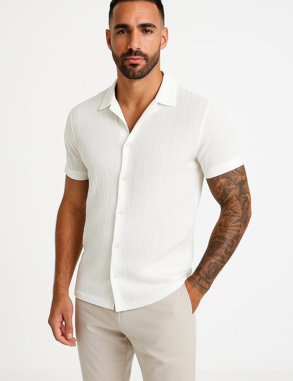 Camicia bianca a maniche corte da uomo, tessuto leggero, abbinata a pantaloni beige. Stile casual elegante, ideale per l'estate.