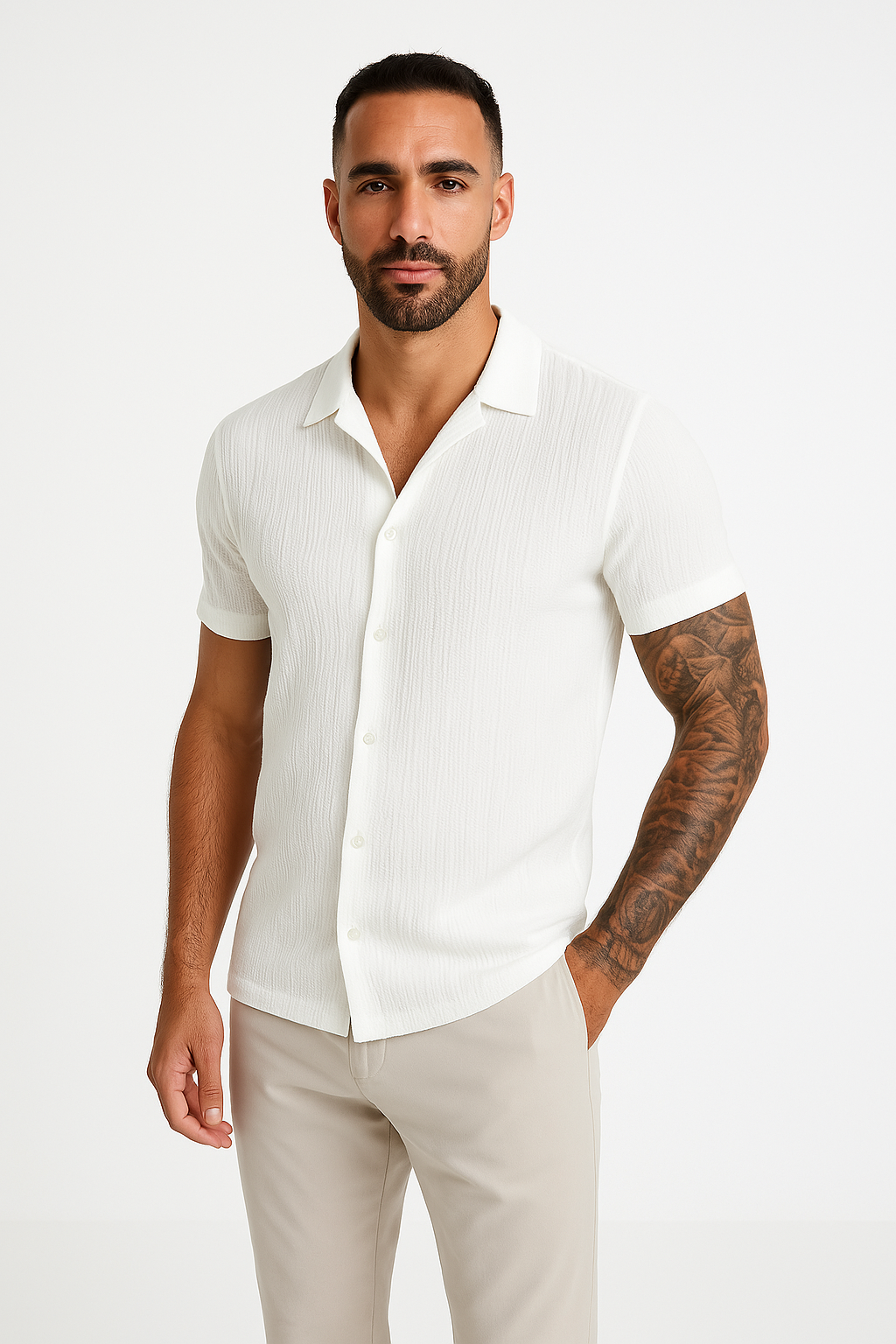 Camicia bianca a maniche corte da uomo, tessuto leggero, abbinata a pantaloni beige. Stile casual elegante, ideale per l'estate.