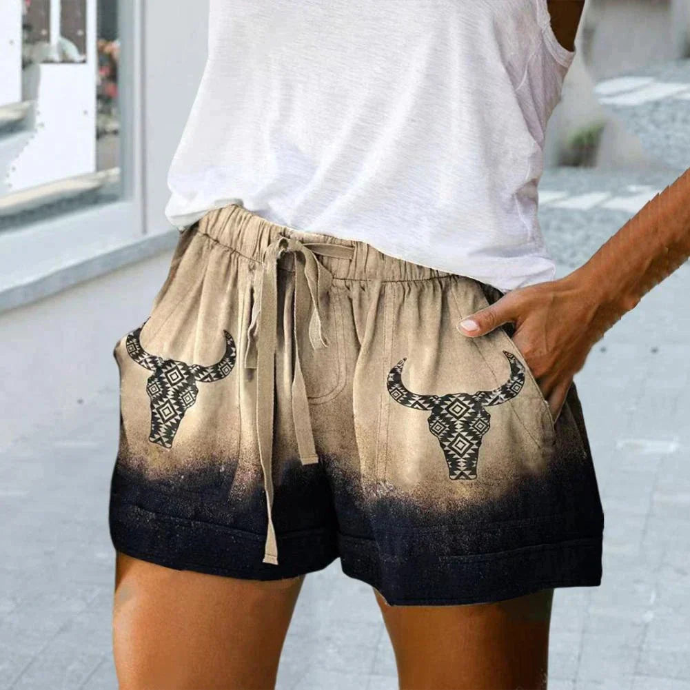 Shorts donna beige e neri con stampa teschio di toro, tasche laterali, cordoncino in vita, stile casual estivo.