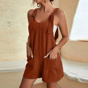 Donna in salopette corta marrone, tessuto leggero, con tasche frontali. Abbigliamento estivo casual, moda femminile, stile rilassato.