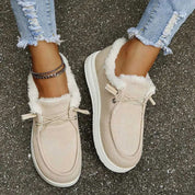 Scarpe da donna beige invernali con pelliccia, suola bianca, indossate con jeans strappati. Calzature casual calde e comode per l'inverno.