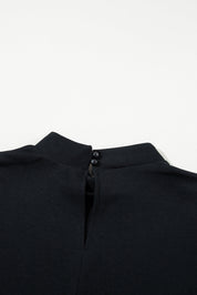 Blusa nera con colletto alto e chiusura a bottone sul retro, elegante e minimalista, perfetta per look formali e casual. Tessuto morbido e confortevole.