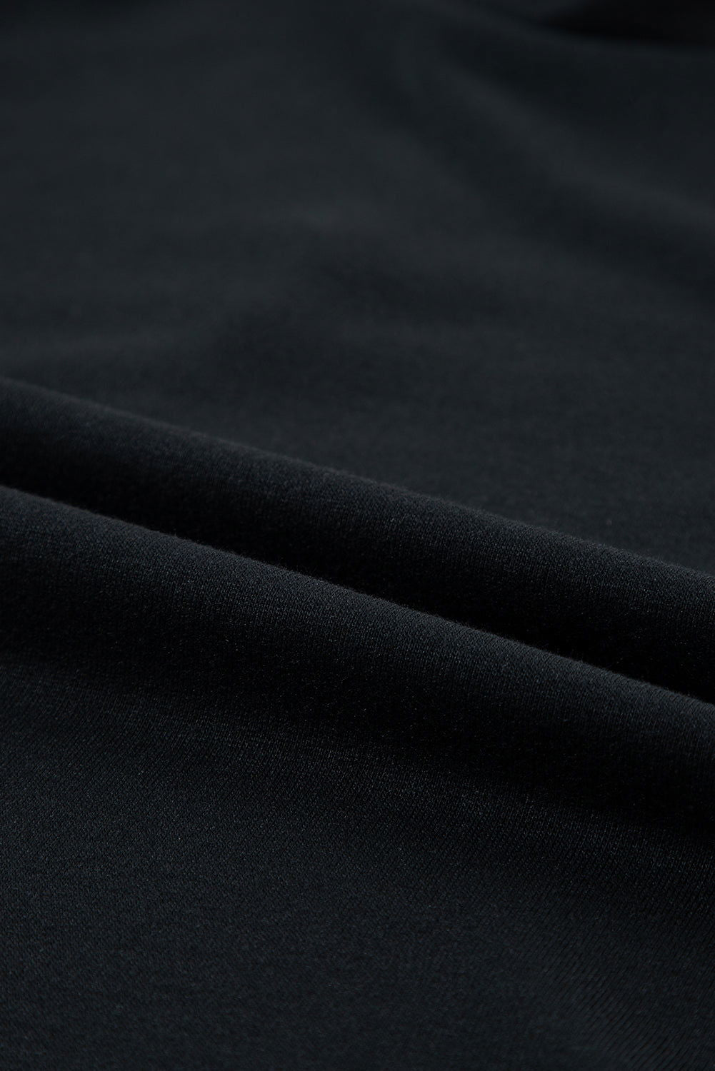 Tessuto nero in cotone, trama liscia e morbida, ideale per abbigliamento e moda. Materiale di alta qualità, perfetto per cucito e design tessile.