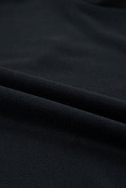 Tessuto nero in cotone, trama liscia e morbida, ideale per abbigliamento e moda. Materiale di alta qualità, perfetto per cucito e design tessile.