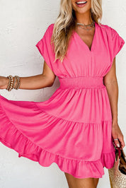 Abito estivo rosa donna, scollo a V, maniche corte, vita arricciata, gonna a balze. Moda femminile elegante, look casual chic.
