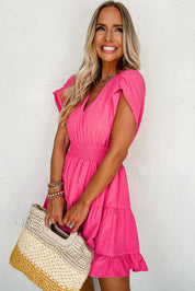 Donna sorridente con abito rosa estivo, maniche corte, e borsa di paglia. Moda femminile, abbigliamento casual elegante, tendenze estive 2023.