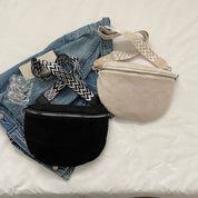 Due borse a tracolla su giacca di jeans, una nera e una beige, con cinghie a motivo geometrico. Accessori moda casual per donna.