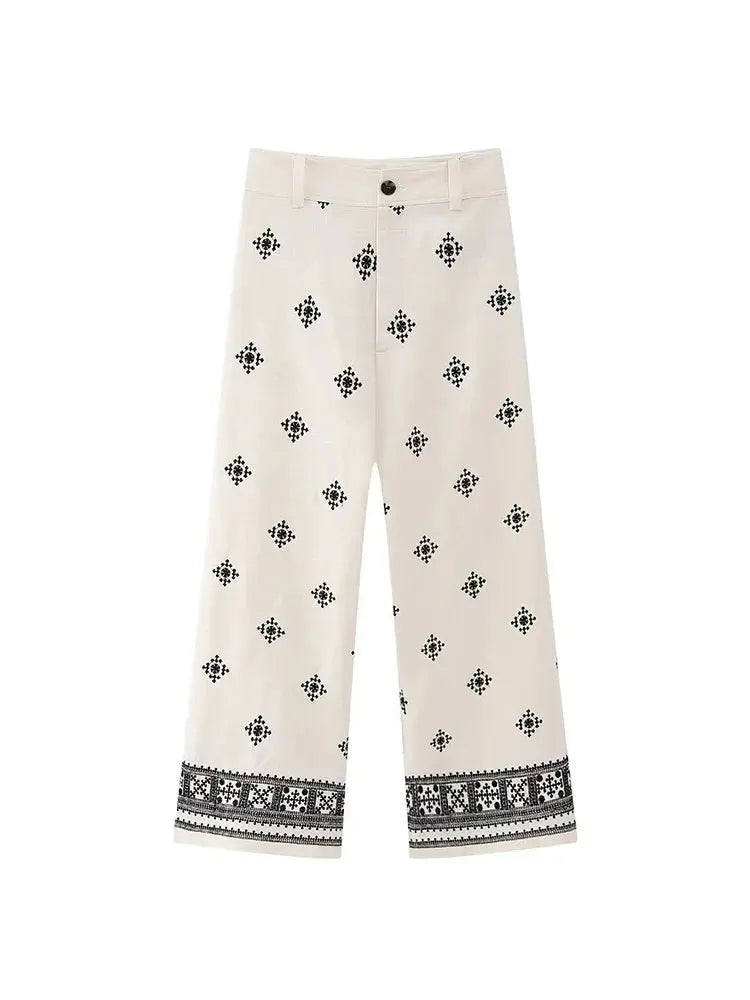 Pantaloni culotte bianchi con motivo geometrico nero, vita media, chiusura a bottone, tessuto leggero. Ideali per moda estiva e casual.