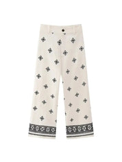 Pantaloni culotte bianchi con motivo geometrico nero, vita media, chiusura a bottone, tessuto leggero. Ideali per moda estiva e casual.