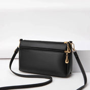 Borsa a tracolla nera in pelle sintetica con cerniere dorate, design elegante e compatto, ideale per moda donna e accessori quotidiani.