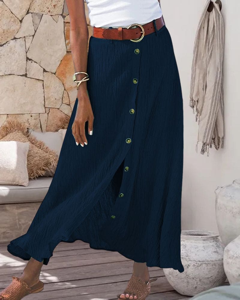 Gonna lunga blu con bottoni, cintura marrone, indossata da una donna. Moda estiva, abbigliamento casual elegante, tessuto leggero.