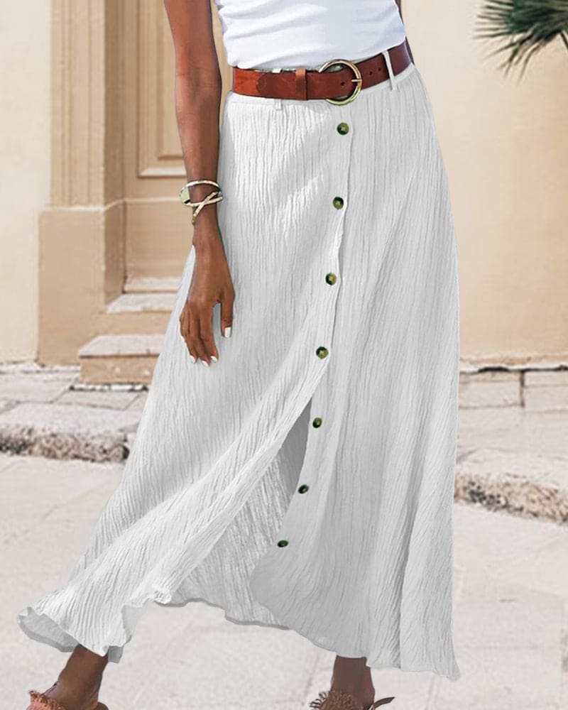 Gonna lunga bianca a bottoni, tessuto plissettato, cintura marrone, look estivo casual, moda donna, abbigliamento elegante, outfit urbano.