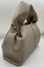 Borsa a mano in pelle beige, design elegante con manico intrecciato, dettagli in metallo dorato. Accessorio moda donna, stile sofisticato.