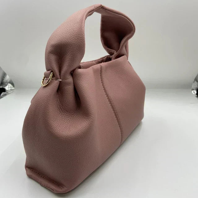 Borsa a mano in pelle rosa, design elegante con manico morbido, chiusura a bottone dorato. Accessorio moda donna, stile contemporaneo.